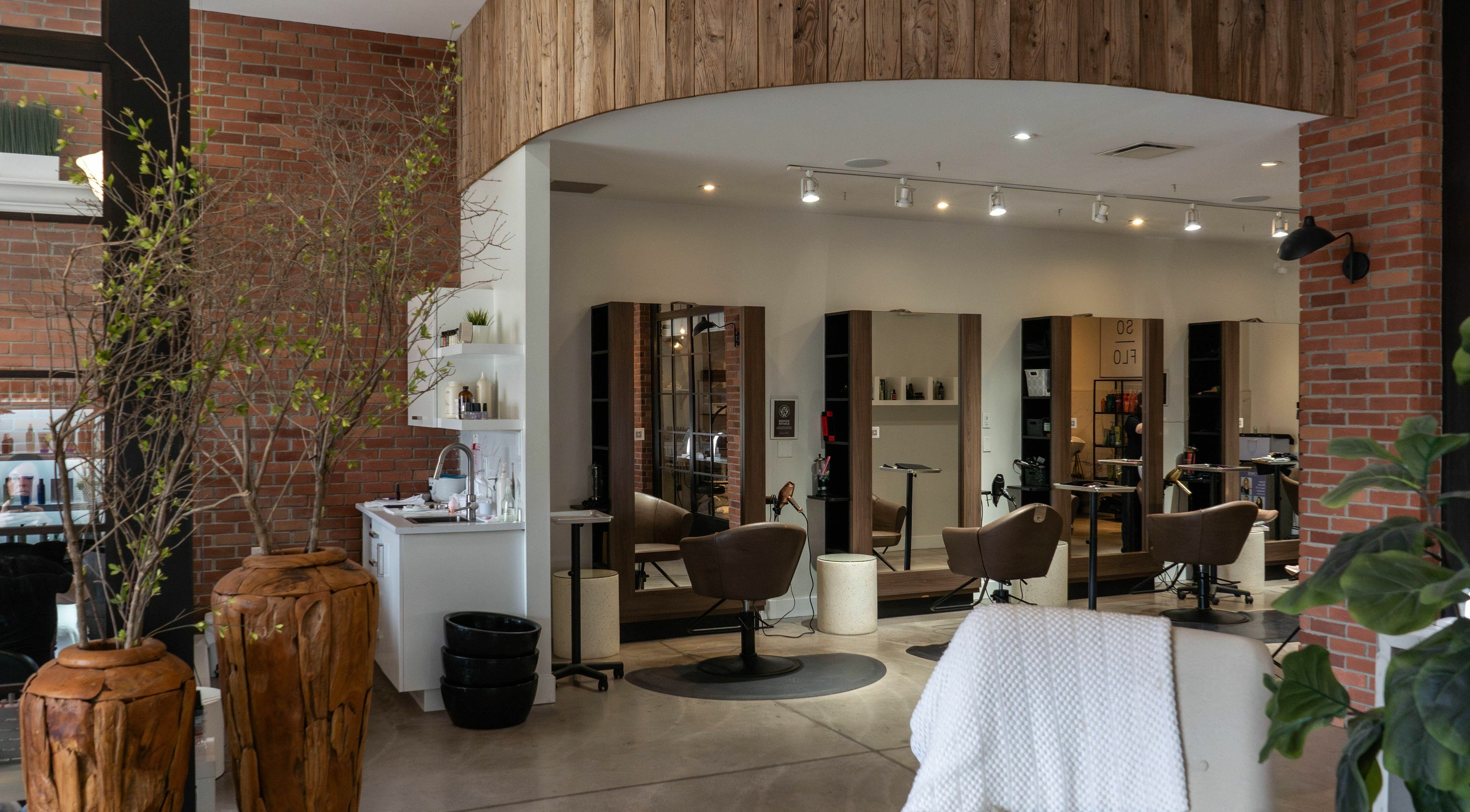 Stylish interior of SoFlo & Co North in Moncton, New Brunswick, CA with modern salon chairs and rustic decor.