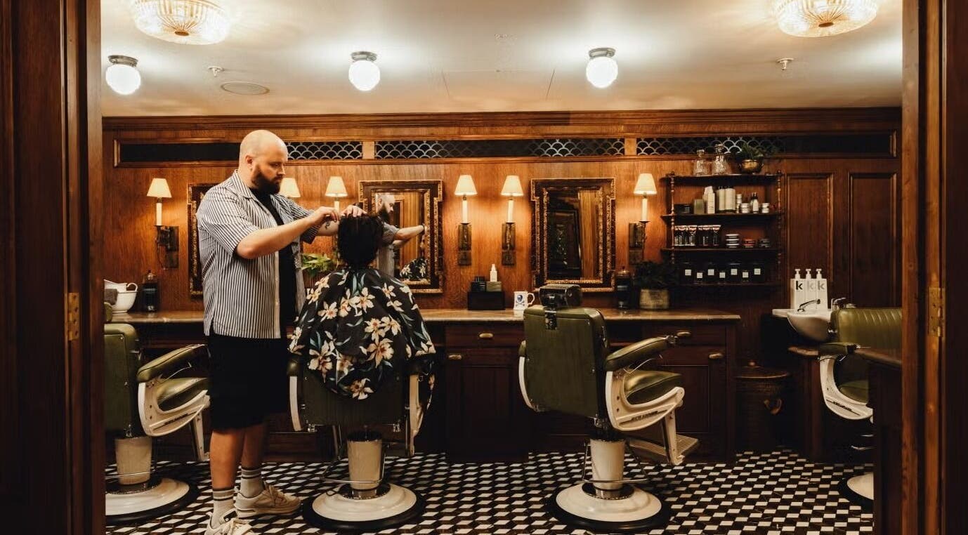 Cozy barber station at lite, London, England, GB featuring vintage chairs and warm lighting.
