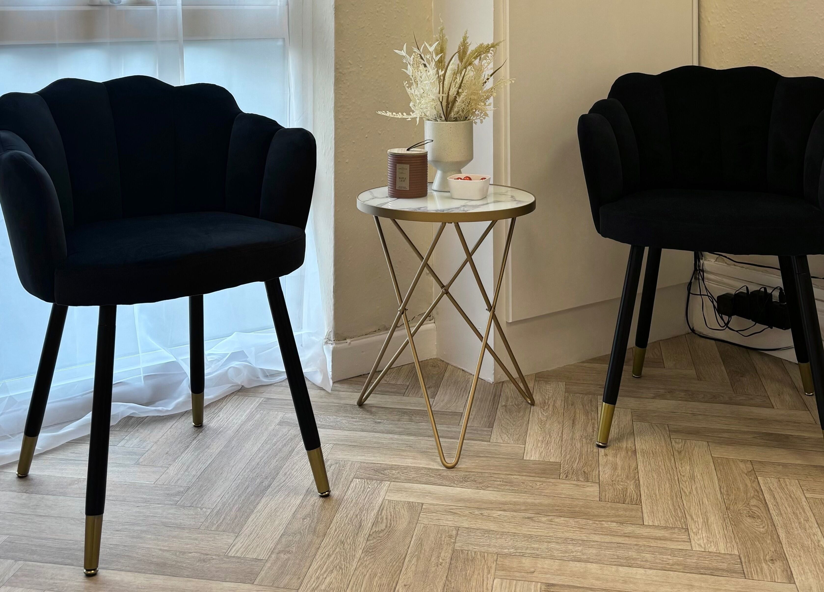 Chic black chairs with a gold-accented table at The Glitter Room, Cannock, England, GB.