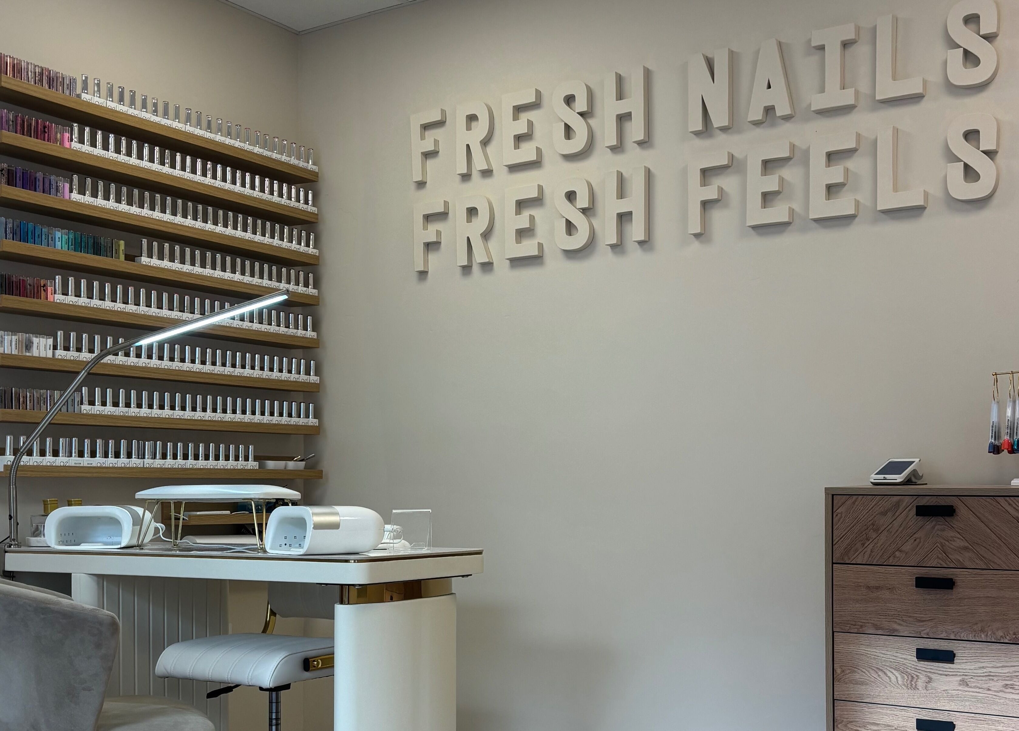 Stylish nail salon workspace at The Glitter Room in Cannock, England, GB with polish shelves and cozy seating.