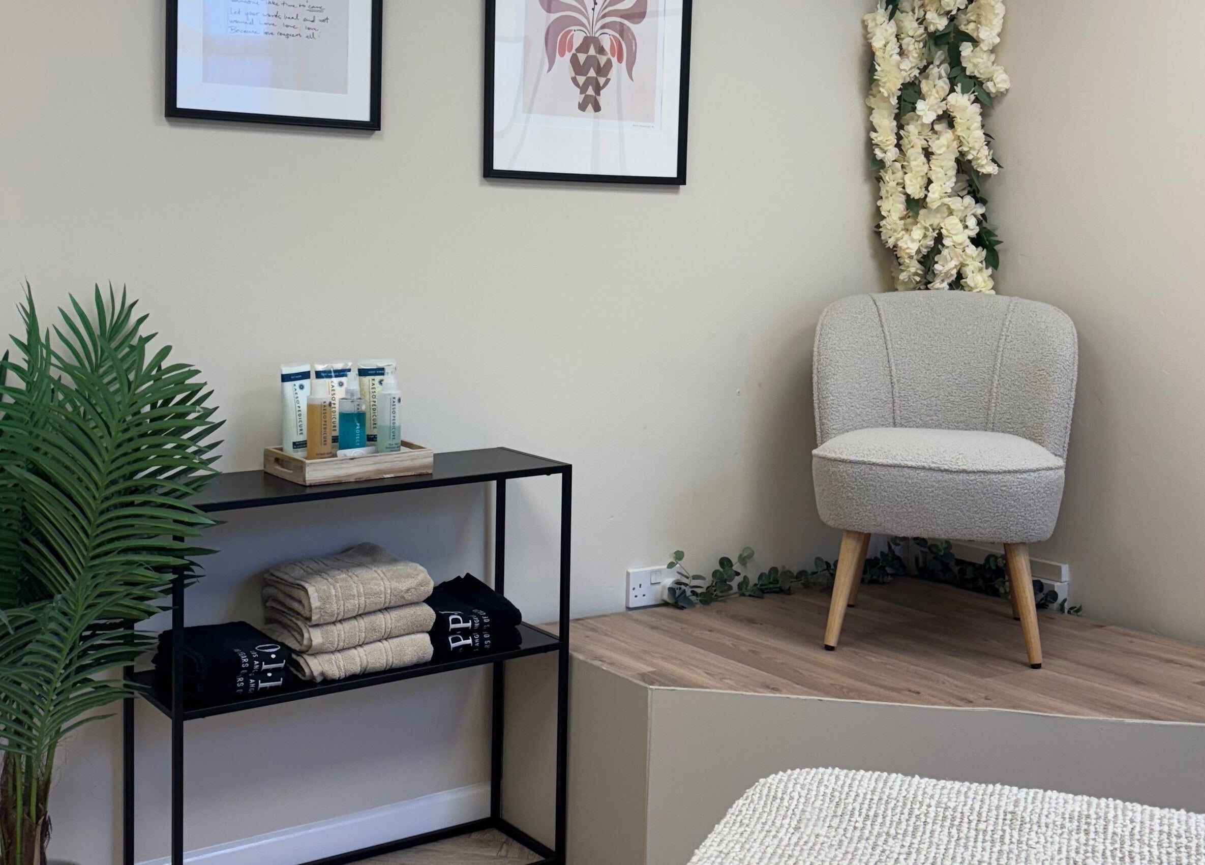 Chic waiting area at The Glitter Room, Cannock, England, GB with chair, plant, and skincare products.