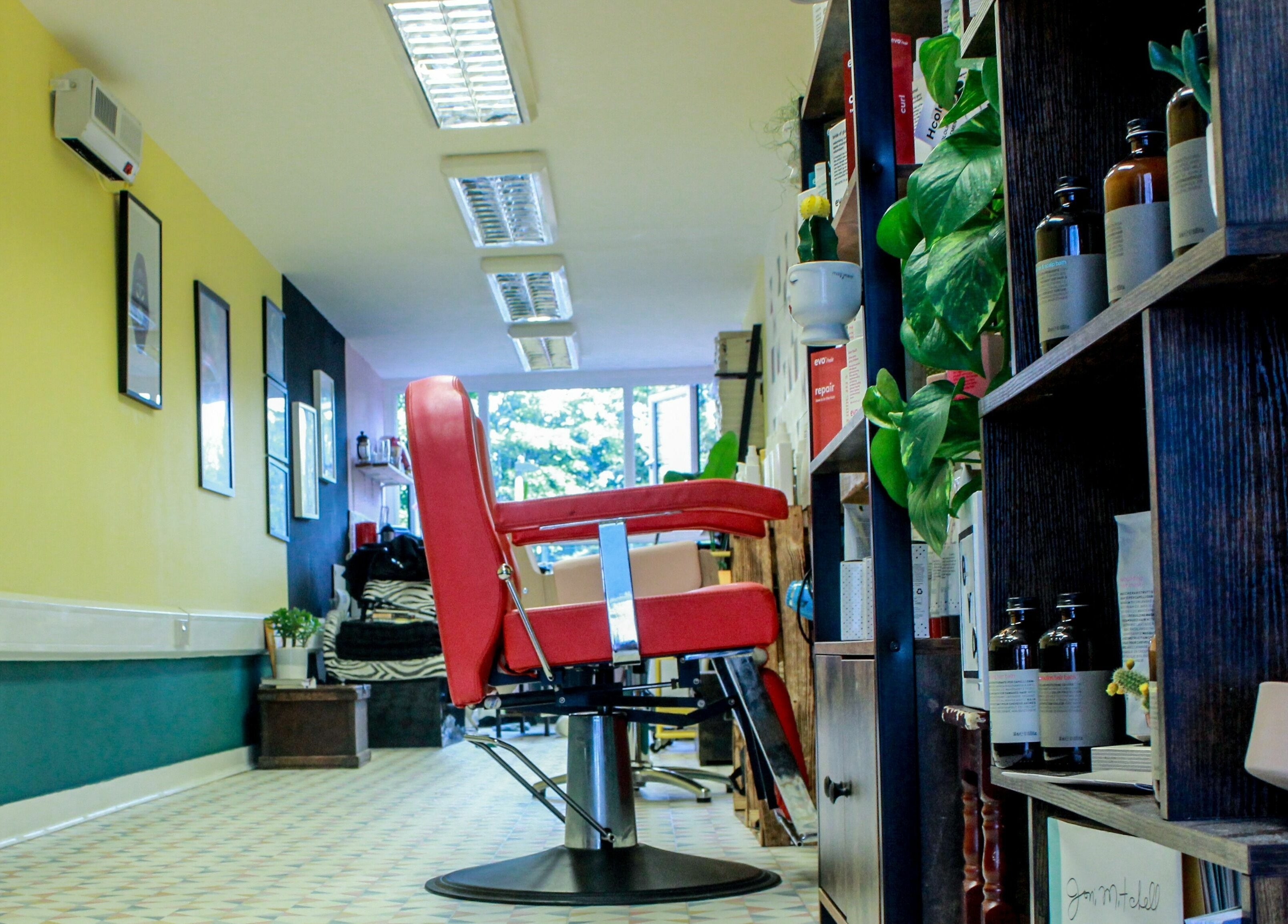 Modern salon interior at Salotto with red chair and yellow walls, located in London, England, GB.