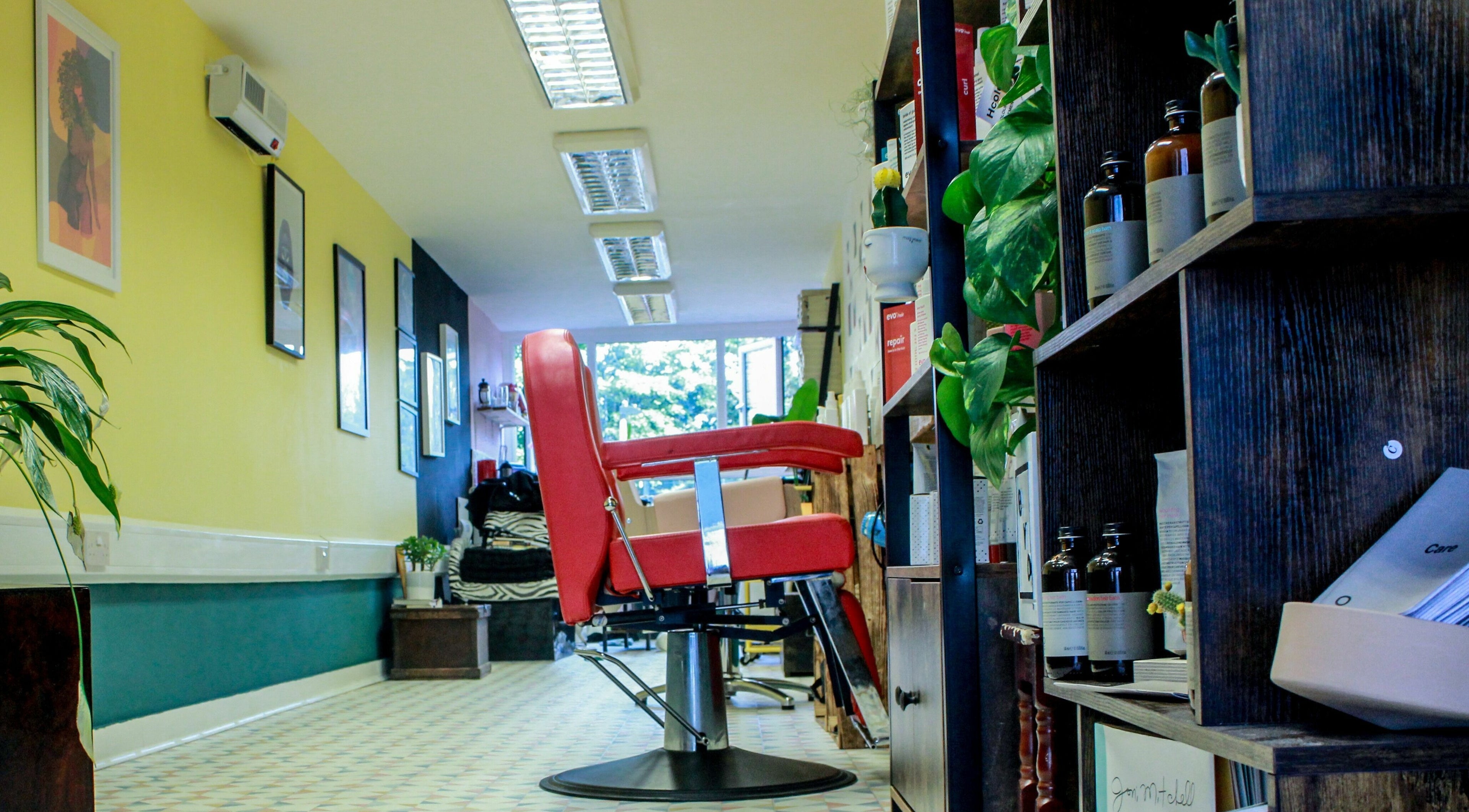 Modern salon interior at Salotto with red chair and yellow walls, located in London, England, GB.
