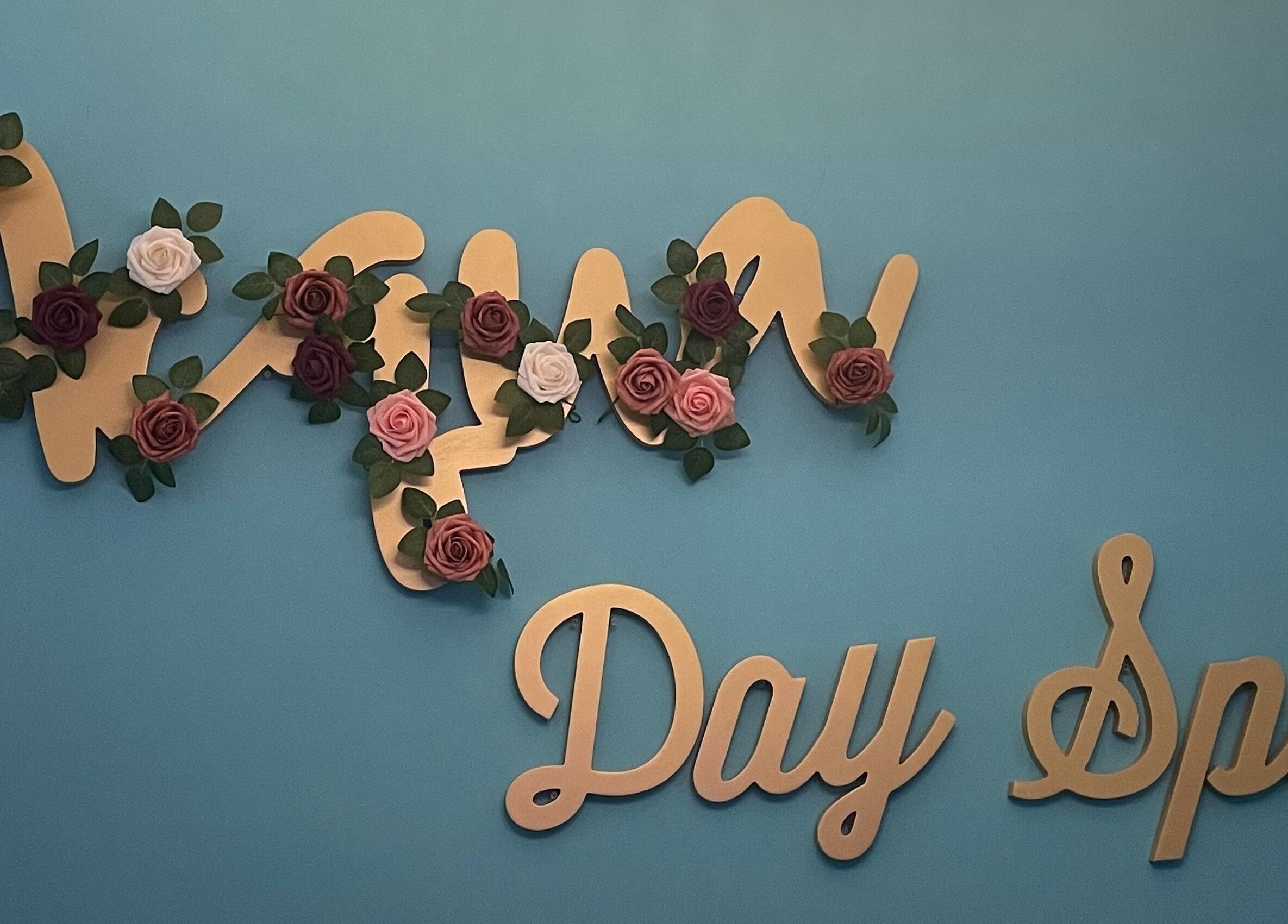 Acqua spa sign adorned with roses on a blue wall in Orlando, Florida, US.