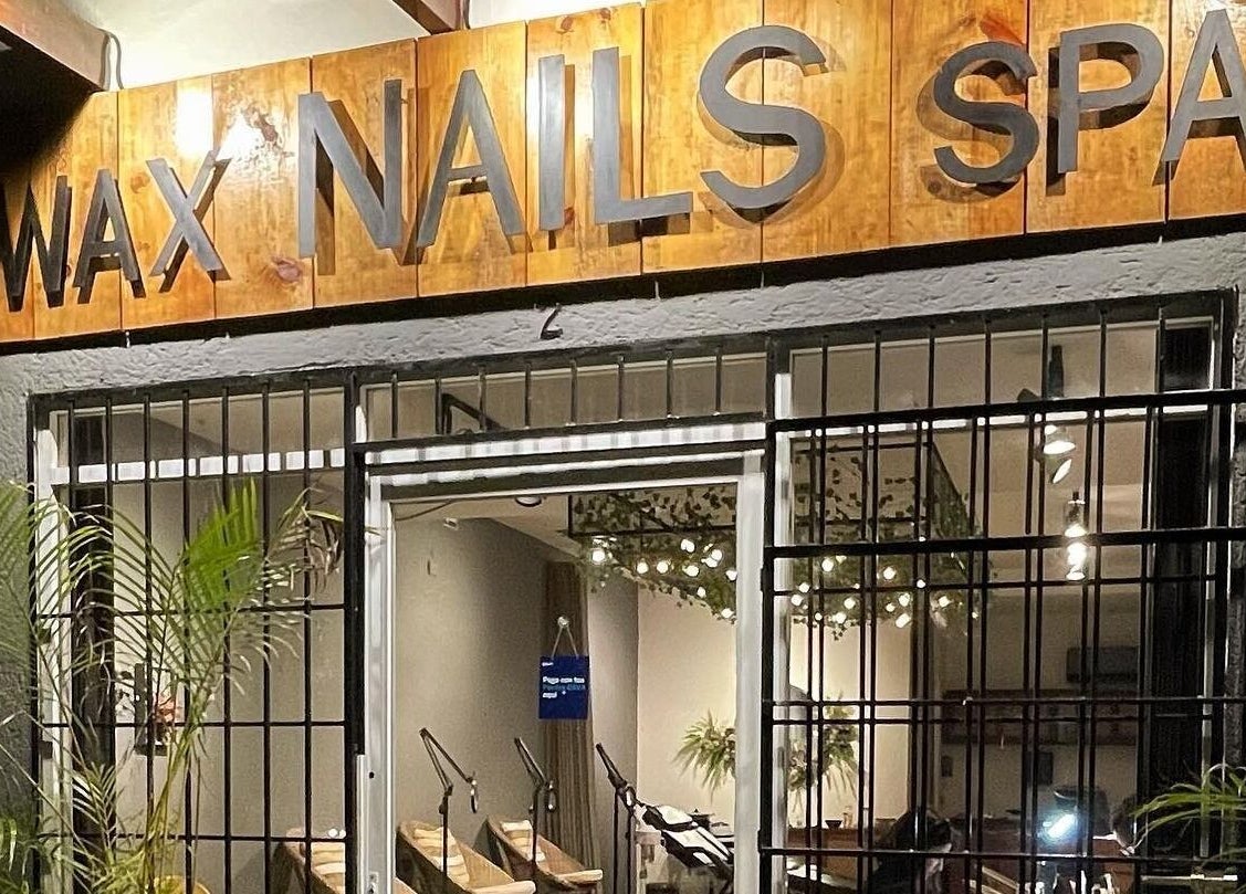 Entrada iluminada de spa en Younik Tulum, Tulum, Quintana Roo, MX con plantas verdes y luces acogedoras.