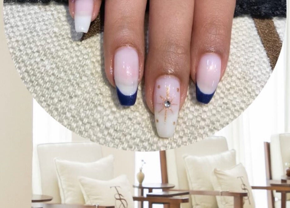 Stylish nail art at The Space Beauty Lounge, أبوظبي, Abu Dhabi, AE with blue tips and a jewel accent.