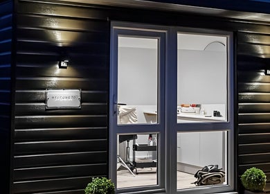 Night view of Jade Lashes Brows Beauty Studio's entrance in Baston, England, GB, showcasing a cozy and inviting atmosphere.