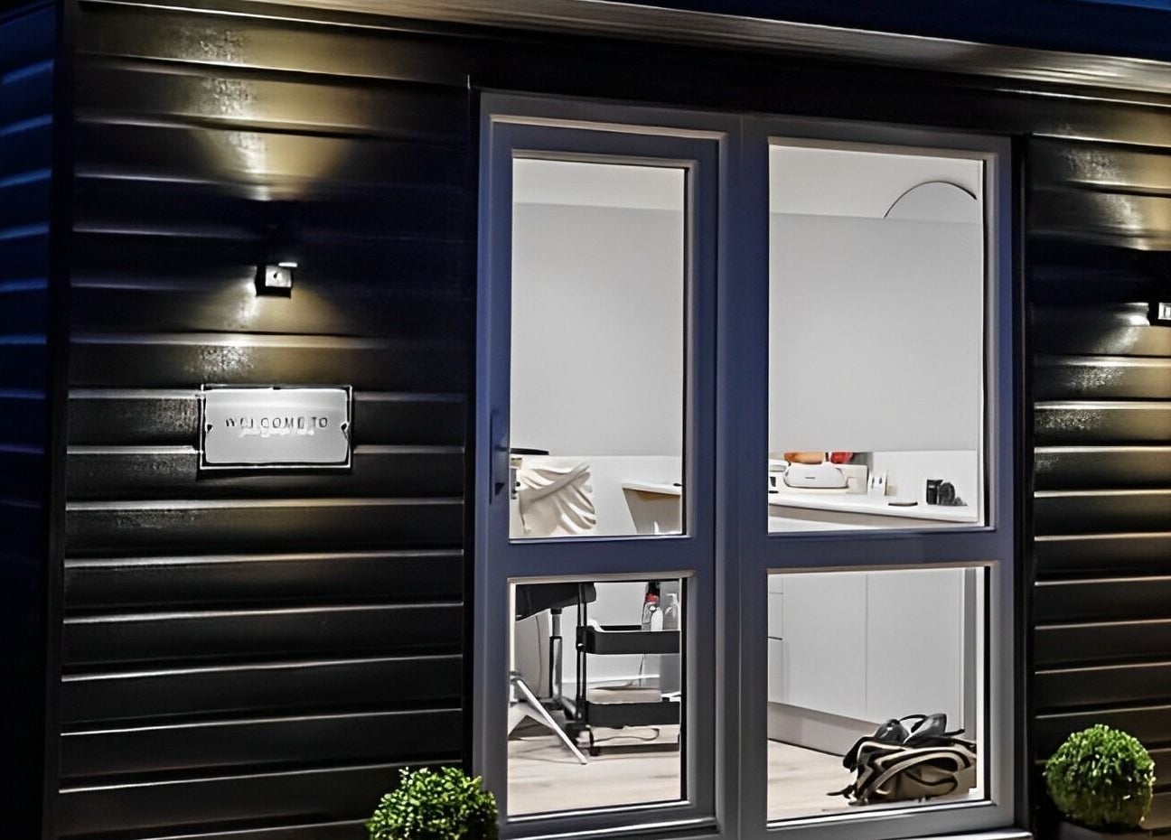 Night view of Jade Lashes Brows Beauty Studio's entrance in Baston, England, GB, showcasing a cozy and inviting atmosphere.