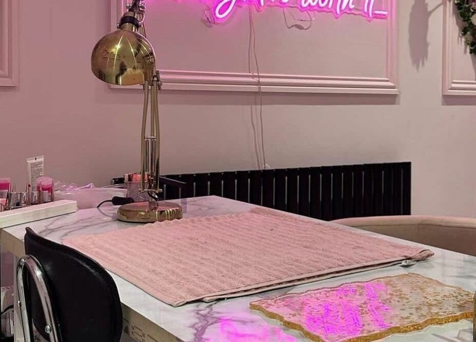 Chic nail station at Fancy Academy Limited in Swinton, England, GB, with pink decor and a golden lamp.