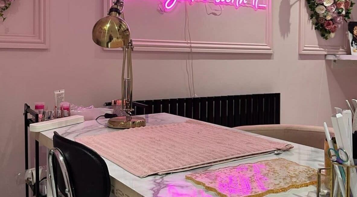 Chic nail station at Fancy Academy Limited in Swinton, England, GB, with pink decor and a golden lamp.