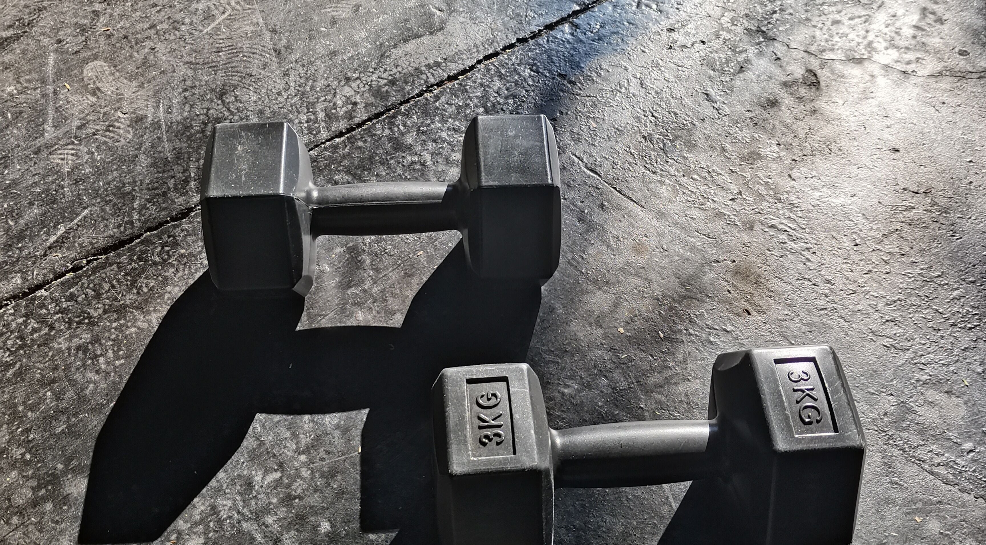 Black dumbbells casting shadows at Vita Amici, Vanderbijlpark, Gauteng, ZA. Perfect for fitness enthusiasts.