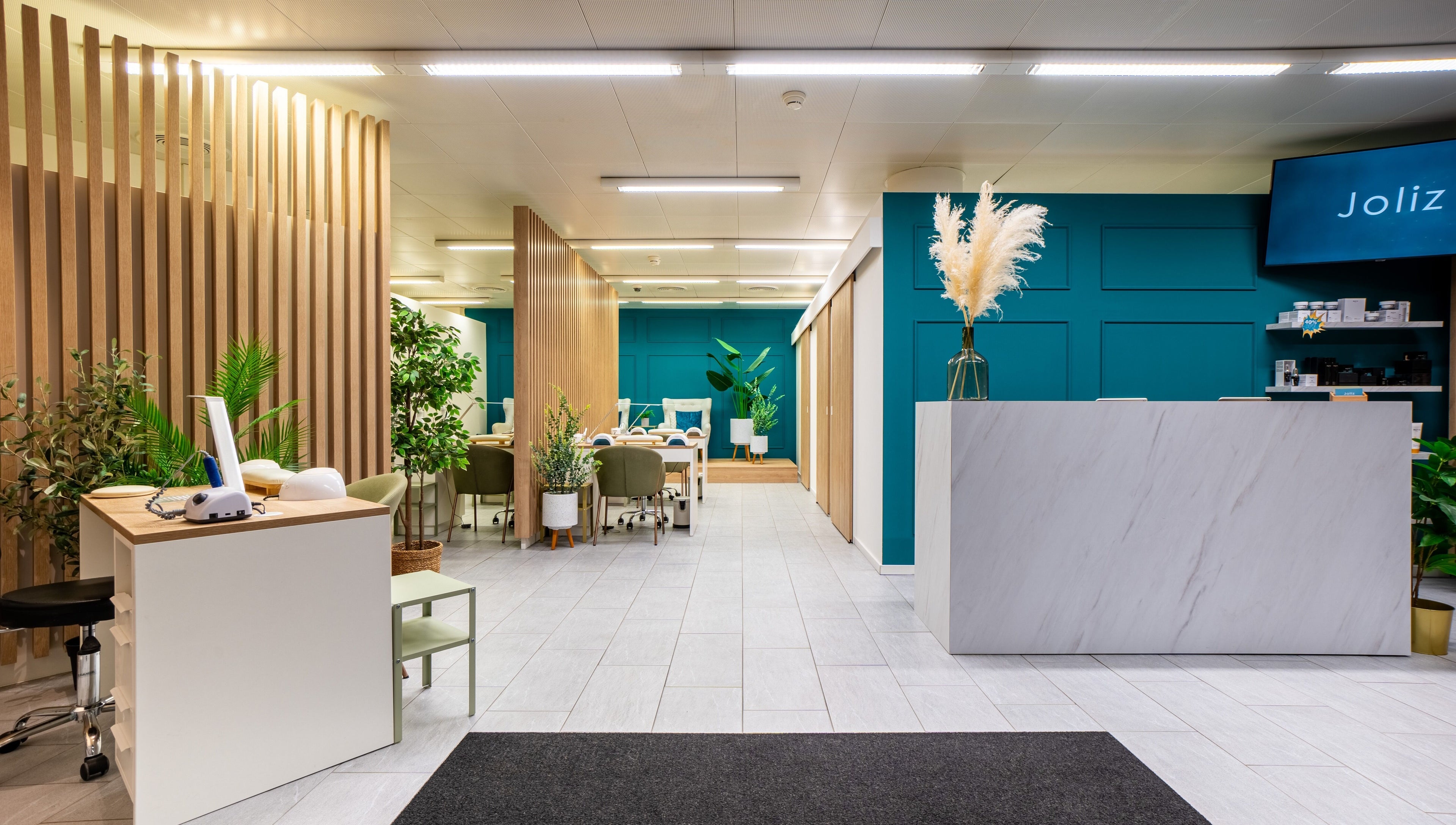 Moderner Empfangsbereich im Joliz, Basel, Basel-Stadt, CH, mit eleganten Linien und Pflanzen.