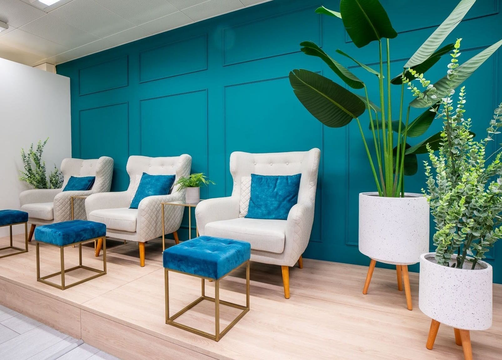 Elegante Wartebereich bei Joliz, Basel, Basel-Stadt, CH mit stilvollen Sesseln und üppigen Pflanzen.