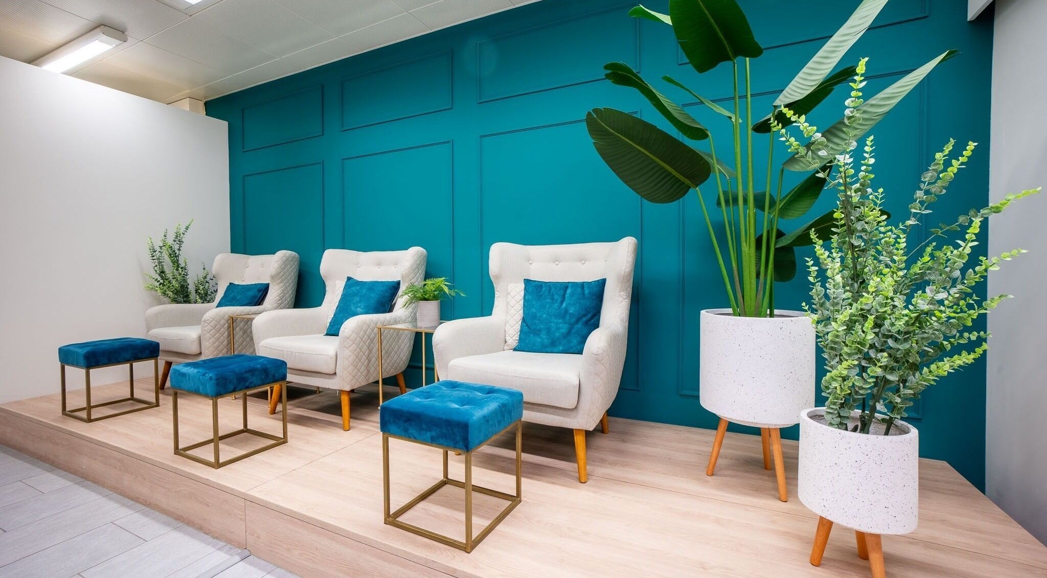 Elegante Wartebereich bei Joliz, Basel, Basel-Stadt, CH mit stilvollen Sesseln und üppigen Pflanzen.