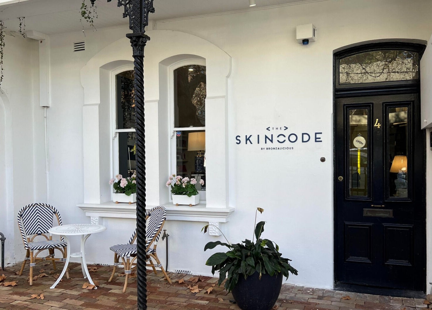 Front view of The Skin Code By Bronzalicious in North Sydney, New South Wales, AU, featuring chic outdoor seating.