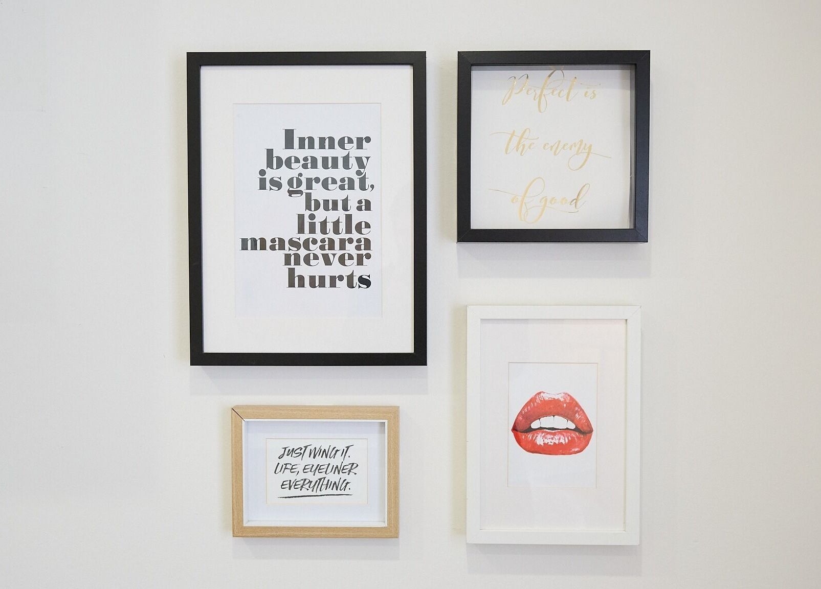 Framed quotes and red lips art on wall at The Skin Code By Bronzalicious, North Sydney, New South Wales, AU.