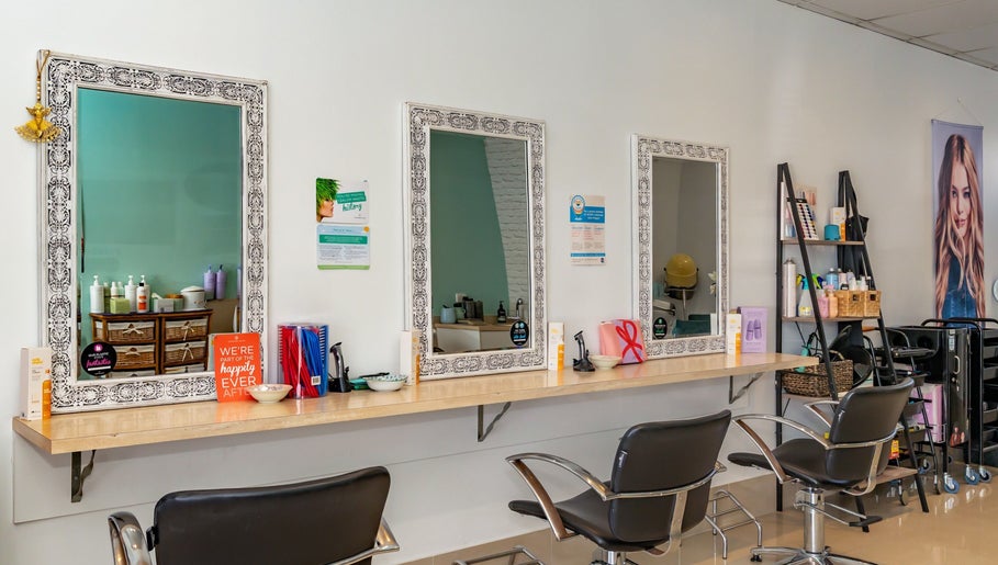 Elegant salon setup at Hideaway Hair in Moffat Beach, Queensland, AU, featuring stylish mirrors and seating.