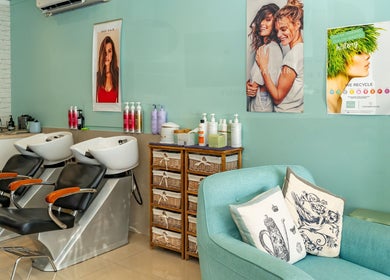 Stylish salon interior at Hideaway Hair, Moffat Beach, Queensland, AU. Two wash stations and cozy seating area.