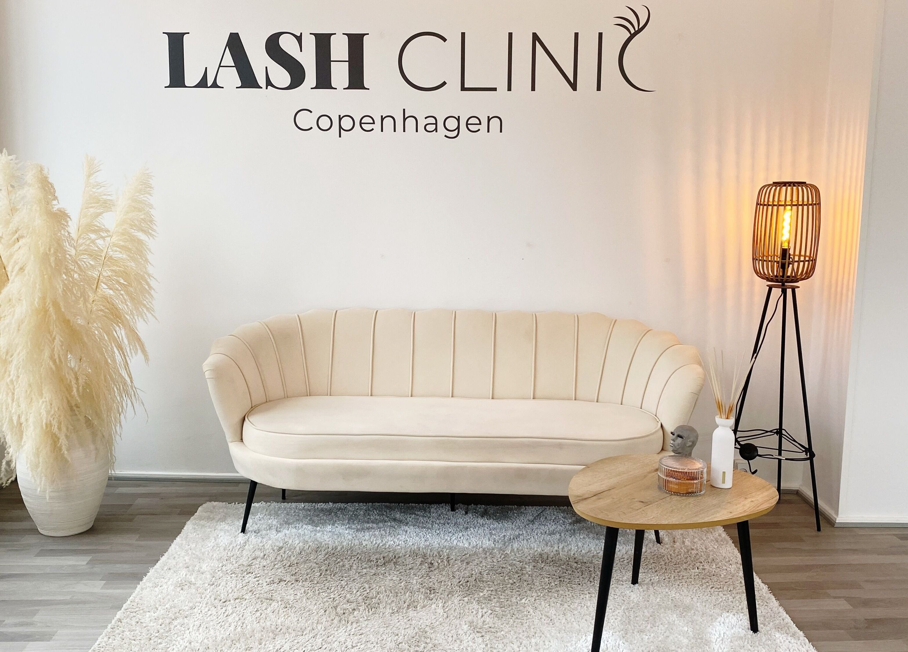Elegant loungeområde hos Lash Clinic Copenhagen i København, Danmark, DK, med beige sofa og moderne lamper.