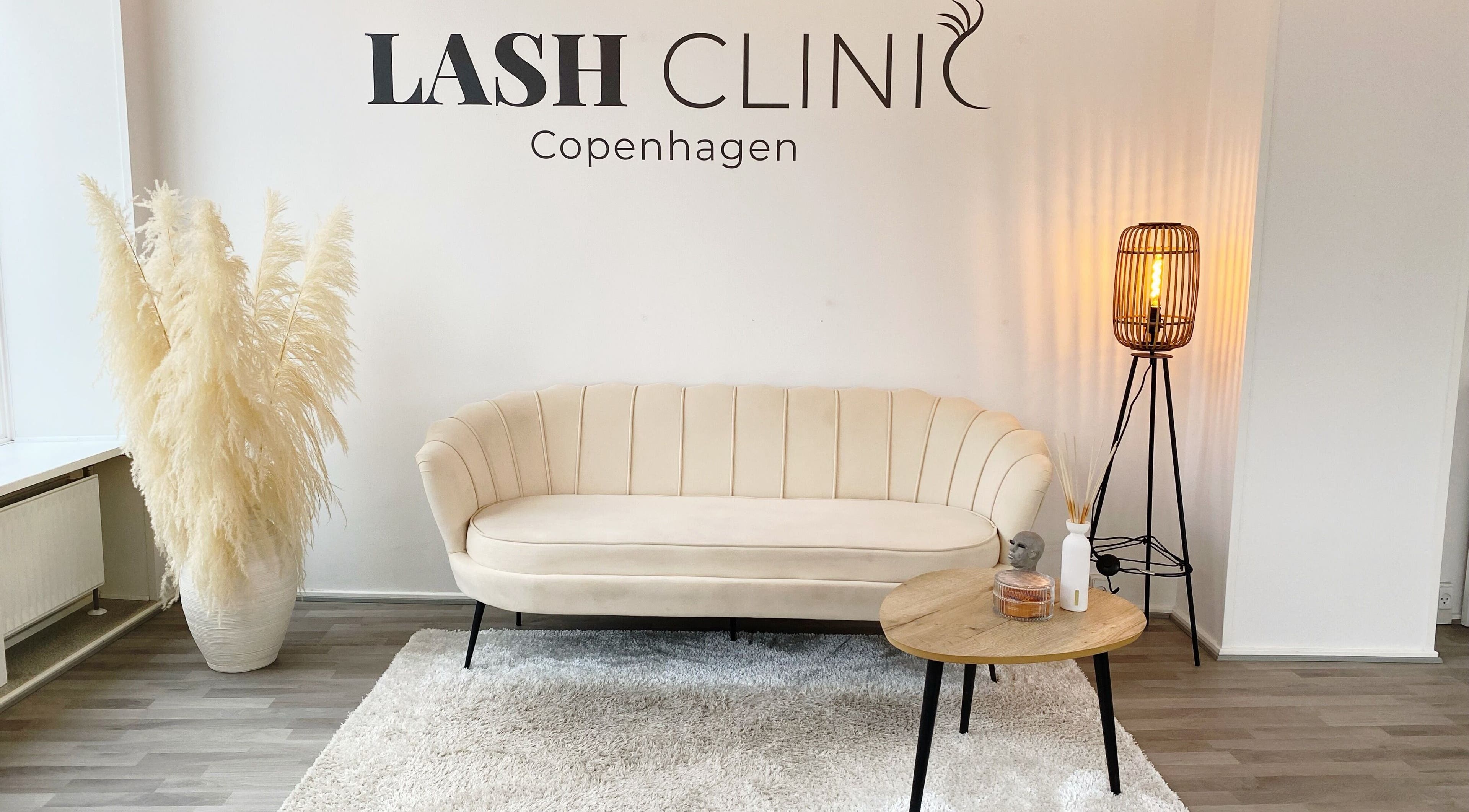 Elegant loungeområde hos Lash Clinic Copenhagen i København, Danmark, DK, med beige sofa og moderne lamper.