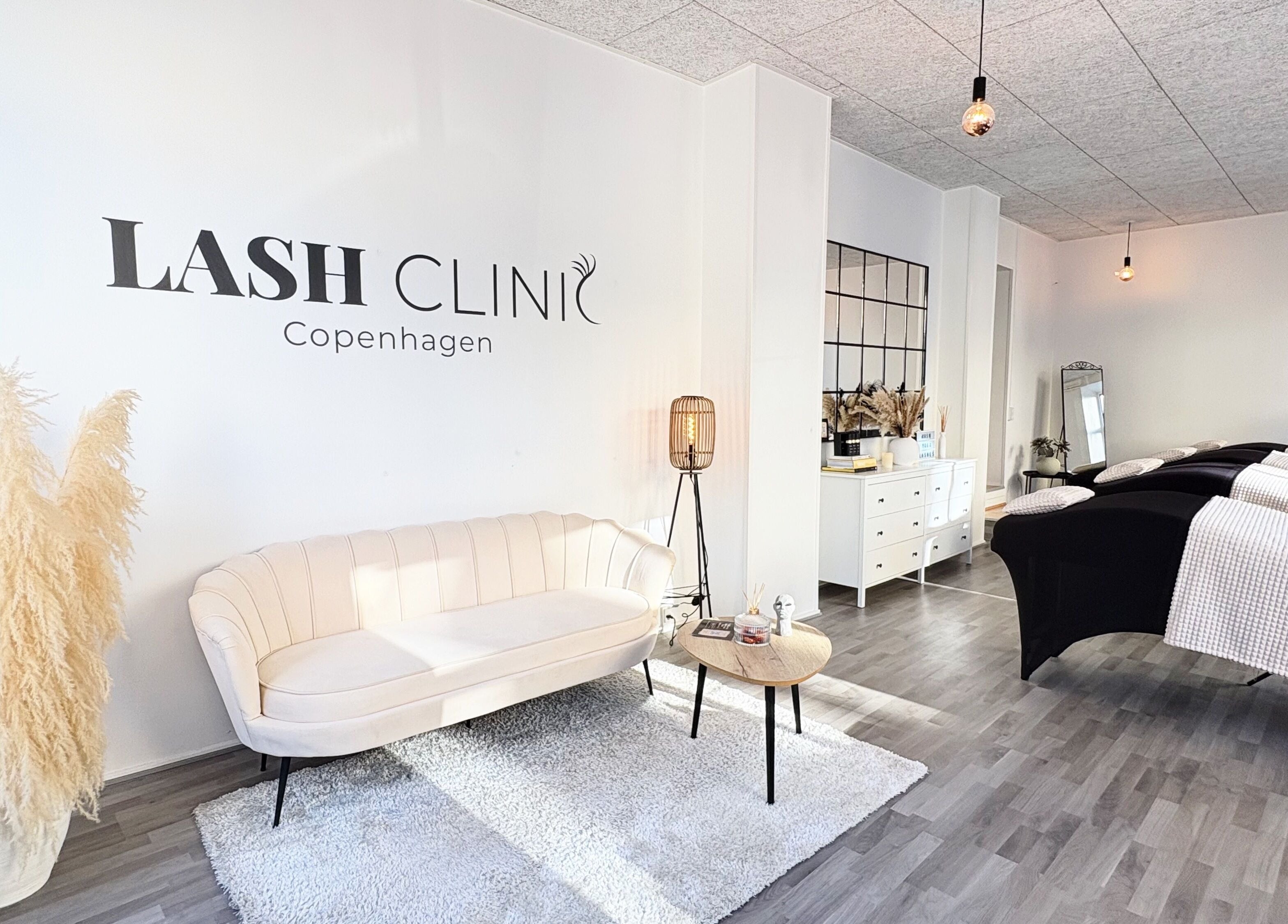 Indbydende interiør hos Lash Clinic Copenhagen i København, DK, med sofa, planter og behandlingsborde.