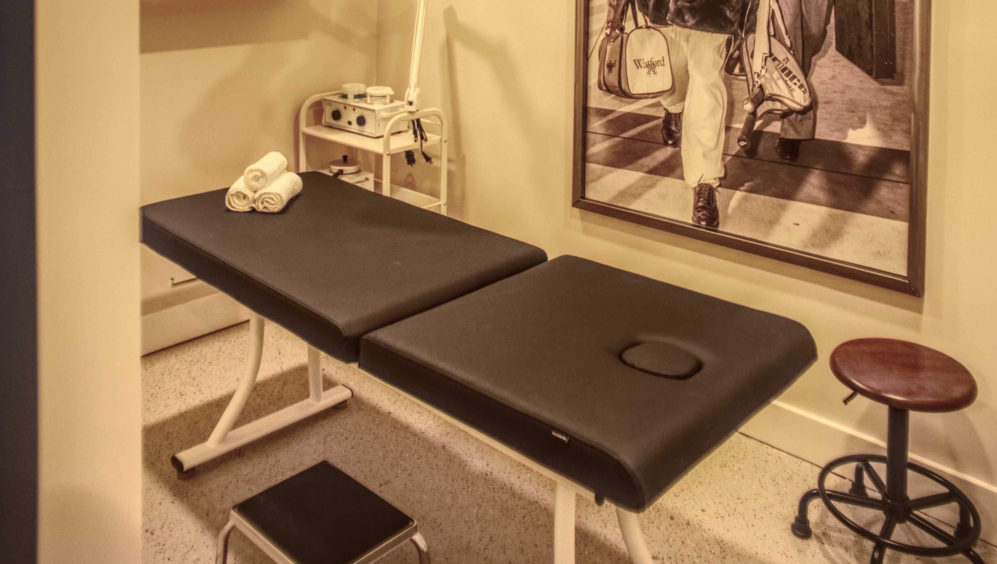 Relaxing treatment room at Menicure Queen West, Toronto, Ontario, CA with massage table and decor.