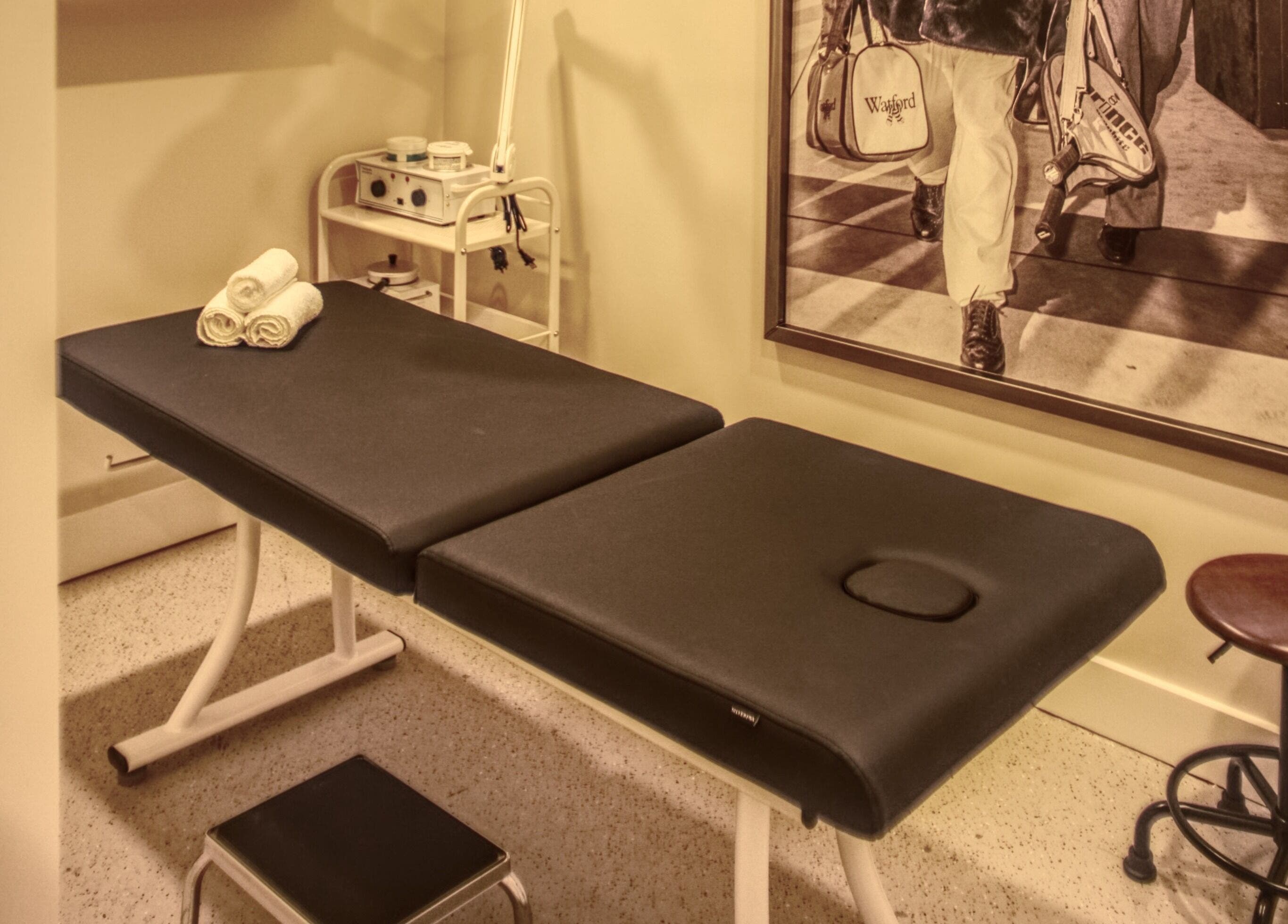 Relaxing treatment room at Menicure Queen West, Toronto, Ontario, CA with massage table and decor.