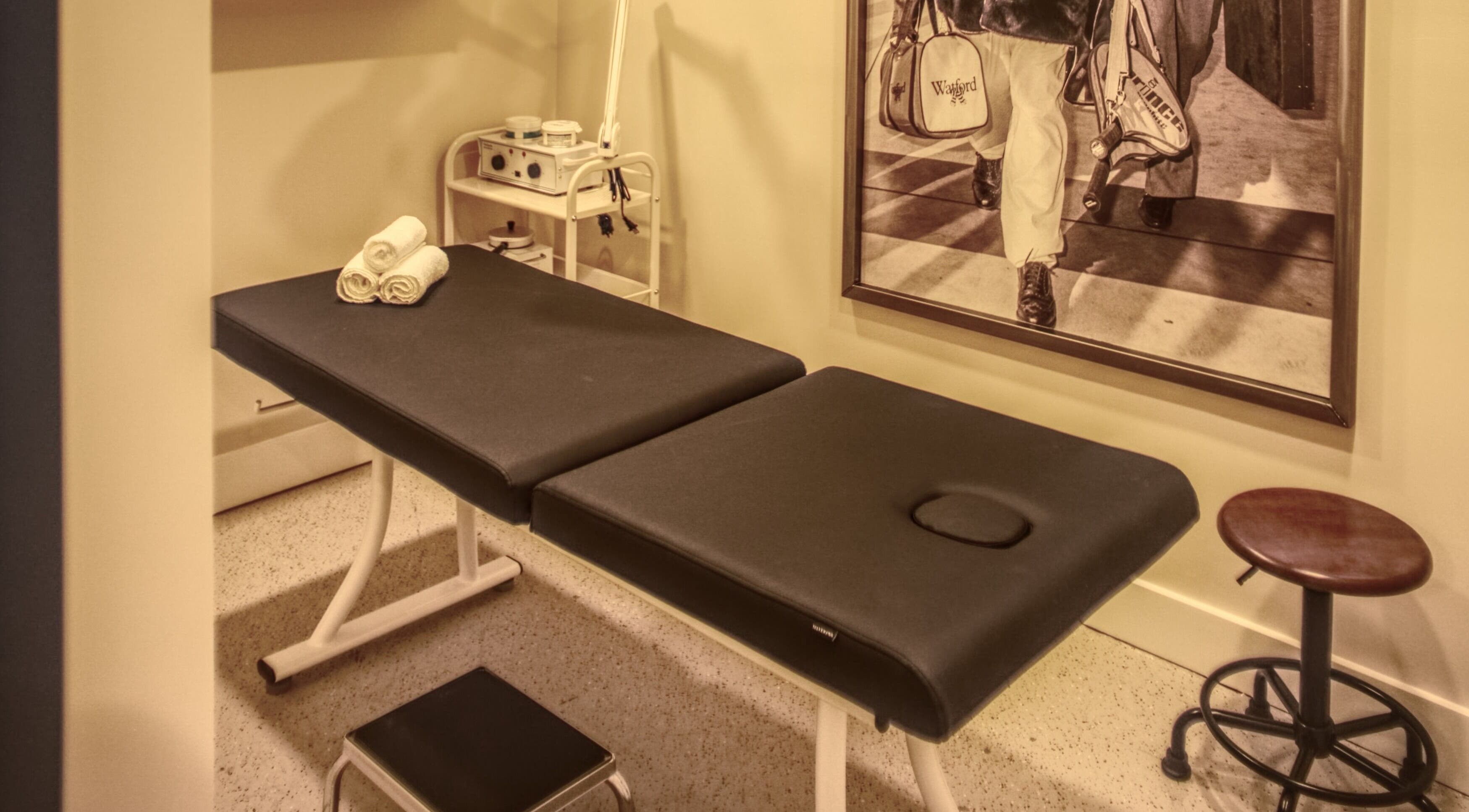 Relaxing treatment room at Menicure Queen West, Toronto, Ontario, CA with massage table and decor.