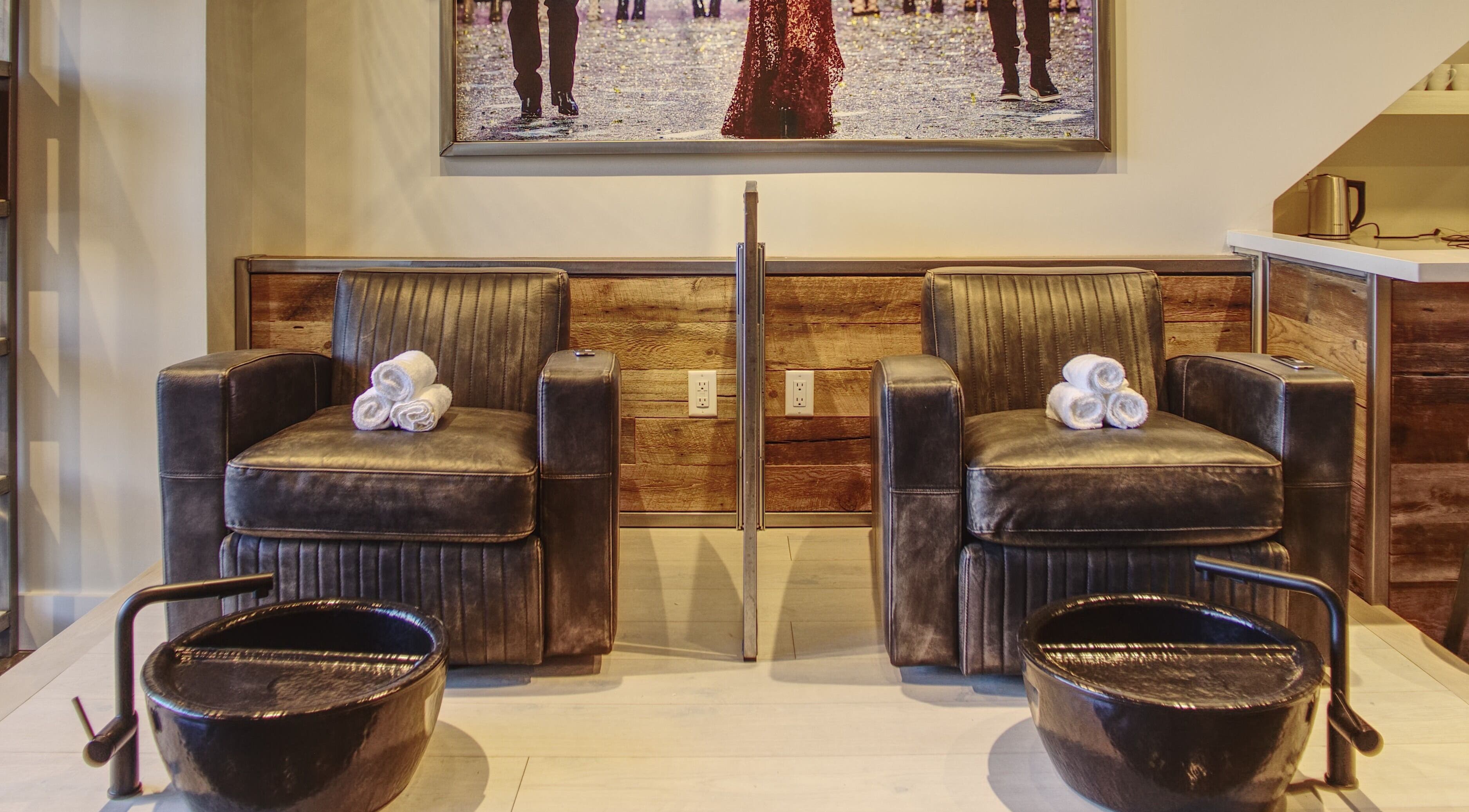 Upscale pedicure chairs and basins at Menicure Queen West in Toronto, Ontario, CA offering a relaxing spa experience.