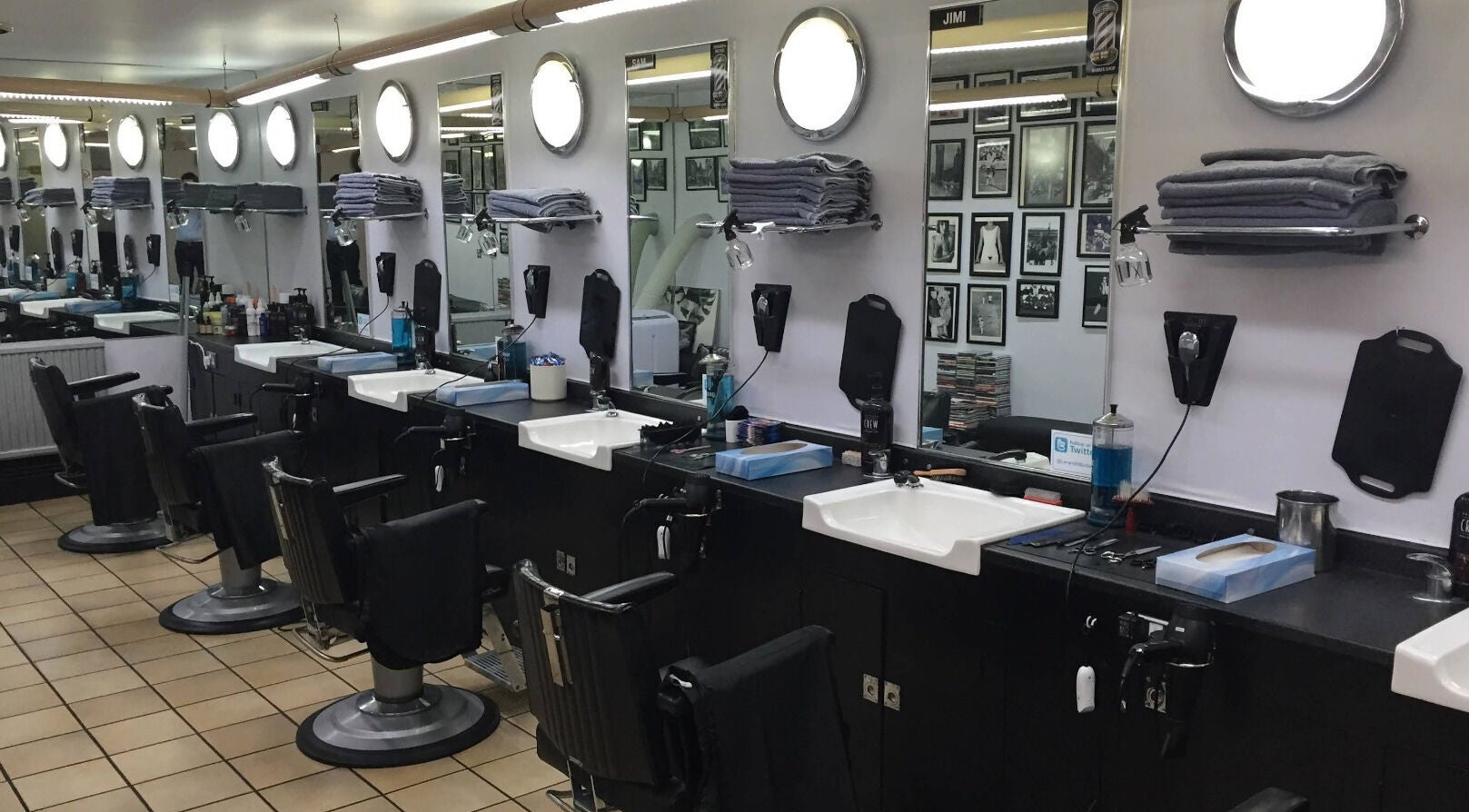 Interior of Leonard and Michael Barbershop in London, England, GB featuring modern styling chairs and mirrors.
