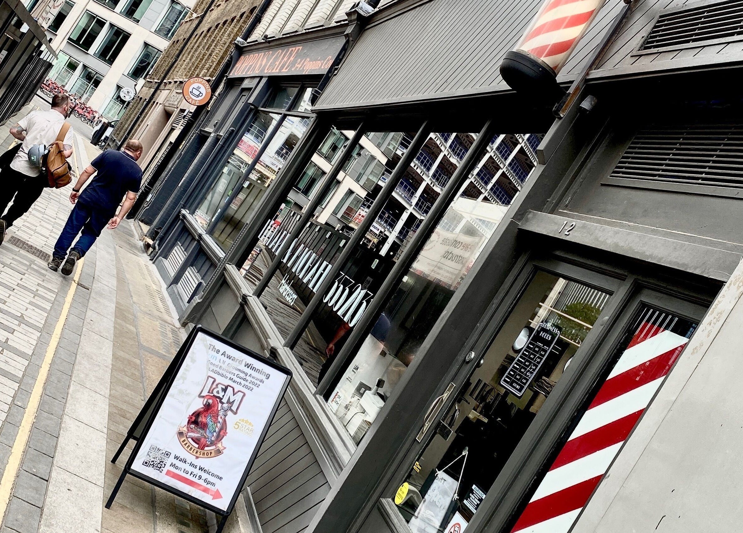 Leonard and Michael Barbershop storefront with iconic pole, London, England, GB.