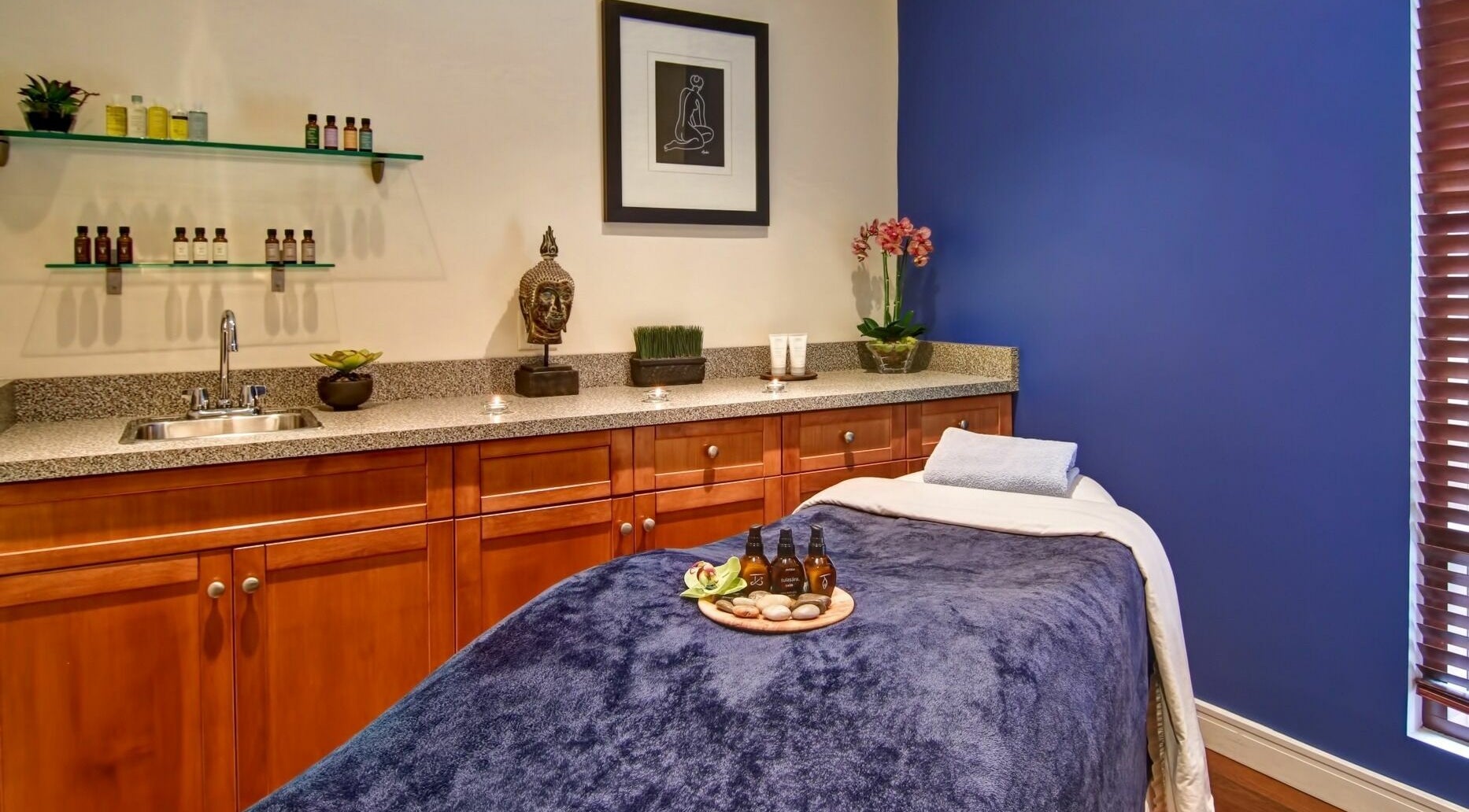 Serene massage room at Five Lakes Spa Aveda, Niagara Falls, Ontario, CA featuring a cozy table and calming decor.