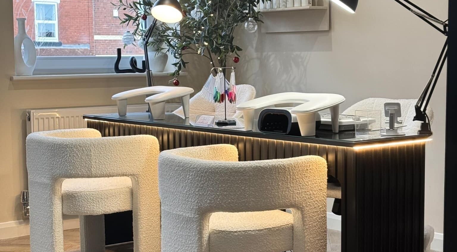 Modern nail care station at The Booth in Shafton, England, GB, featuring plush white chairs and sleek lighting.