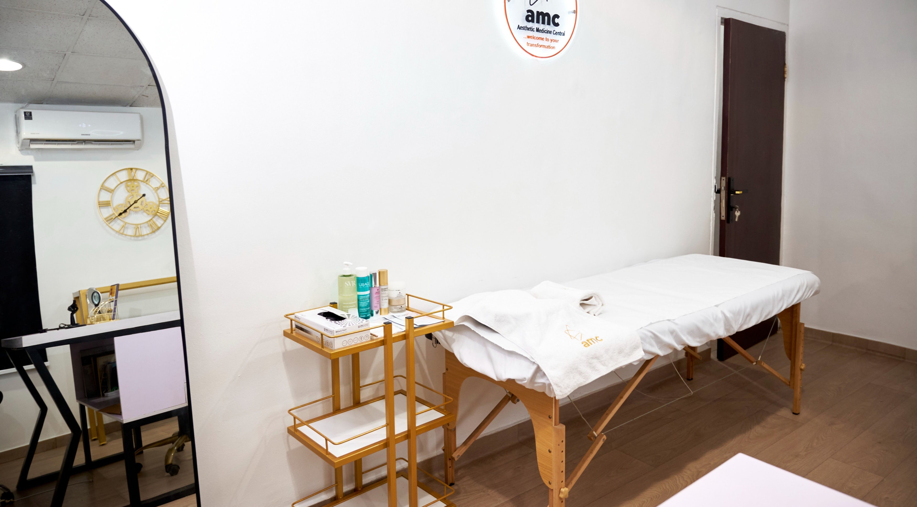 Serene treatment room at Aesthetic Medicine Central, Lagos, Lagos, NG, featuring massage table and spa essentials.