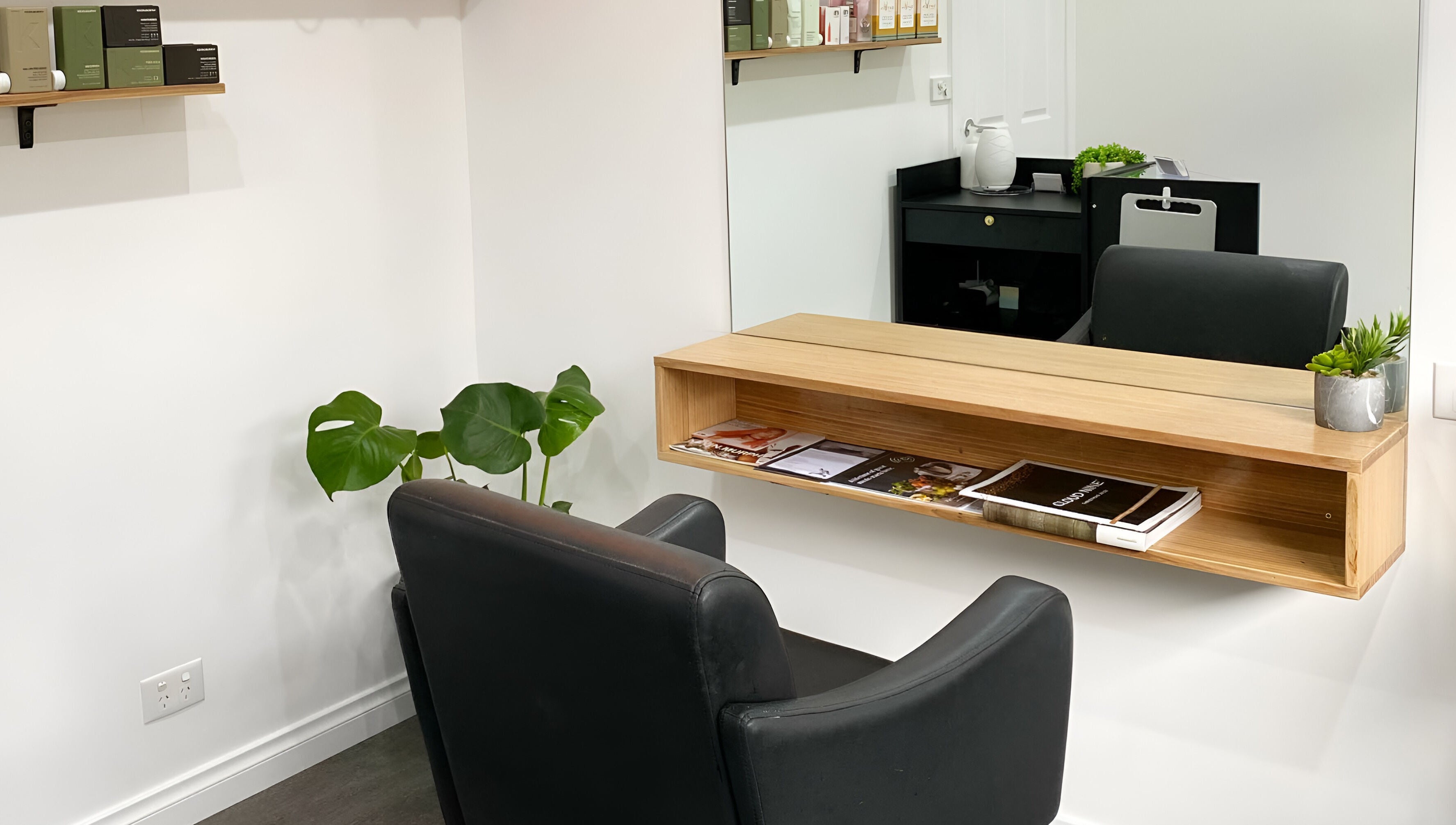 Modern salon interior with black chair and wooden shelf at TLC Hair Bar, Melbourne, Victoria, AU.