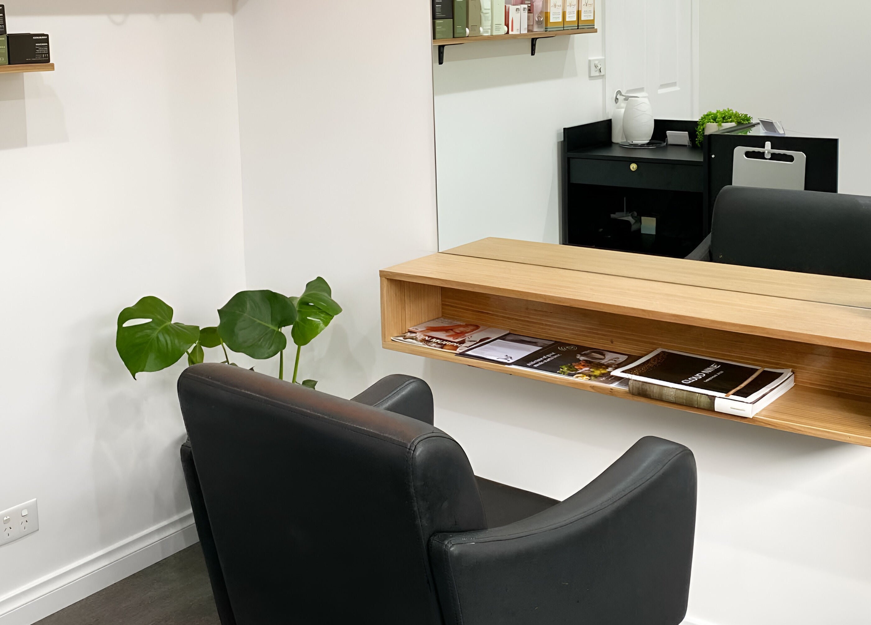 Modern salon interior with black chair and wooden shelf at TLC Hair Bar, Melbourne, Victoria, AU.