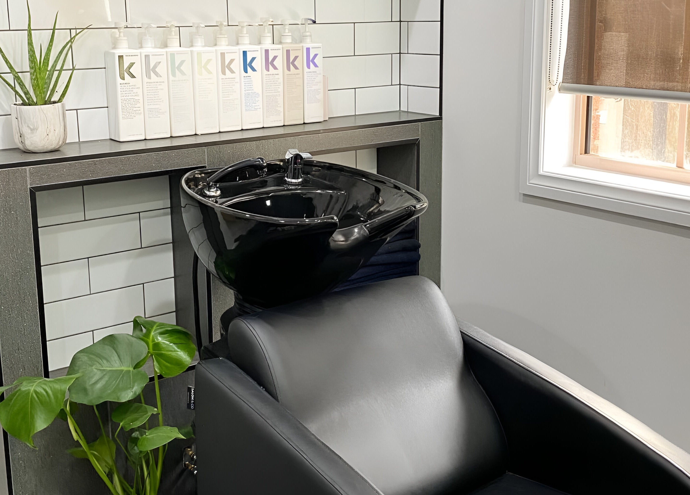 Modern wash station with lush greenery at TLC Hair Bar, Melbourne, Victoria, AU.