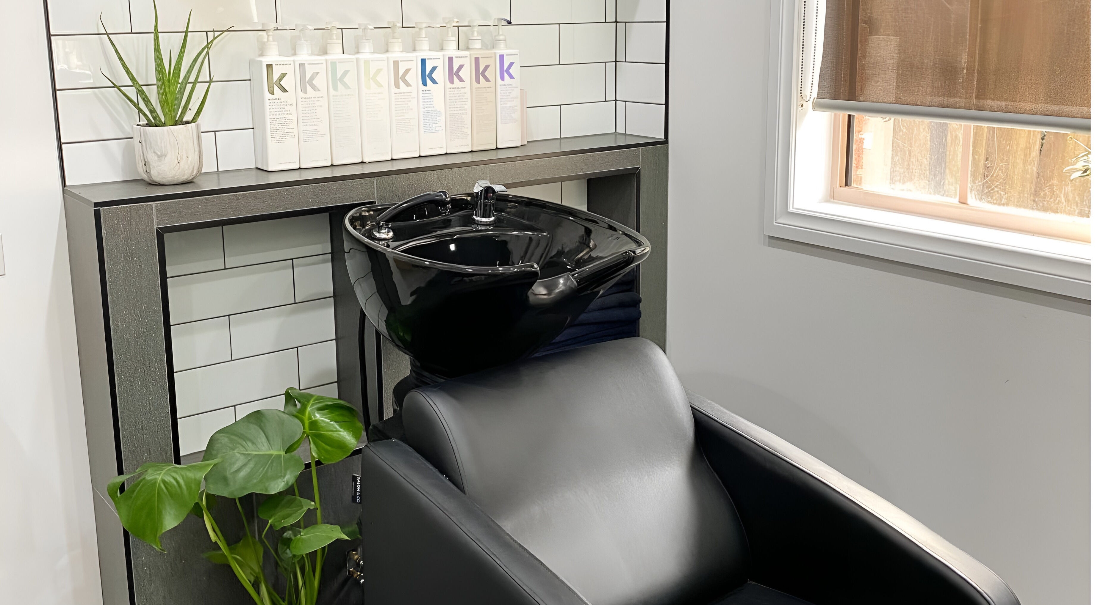 Modern wash station with lush greenery at TLC Hair Bar, Melbourne, Victoria, AU.