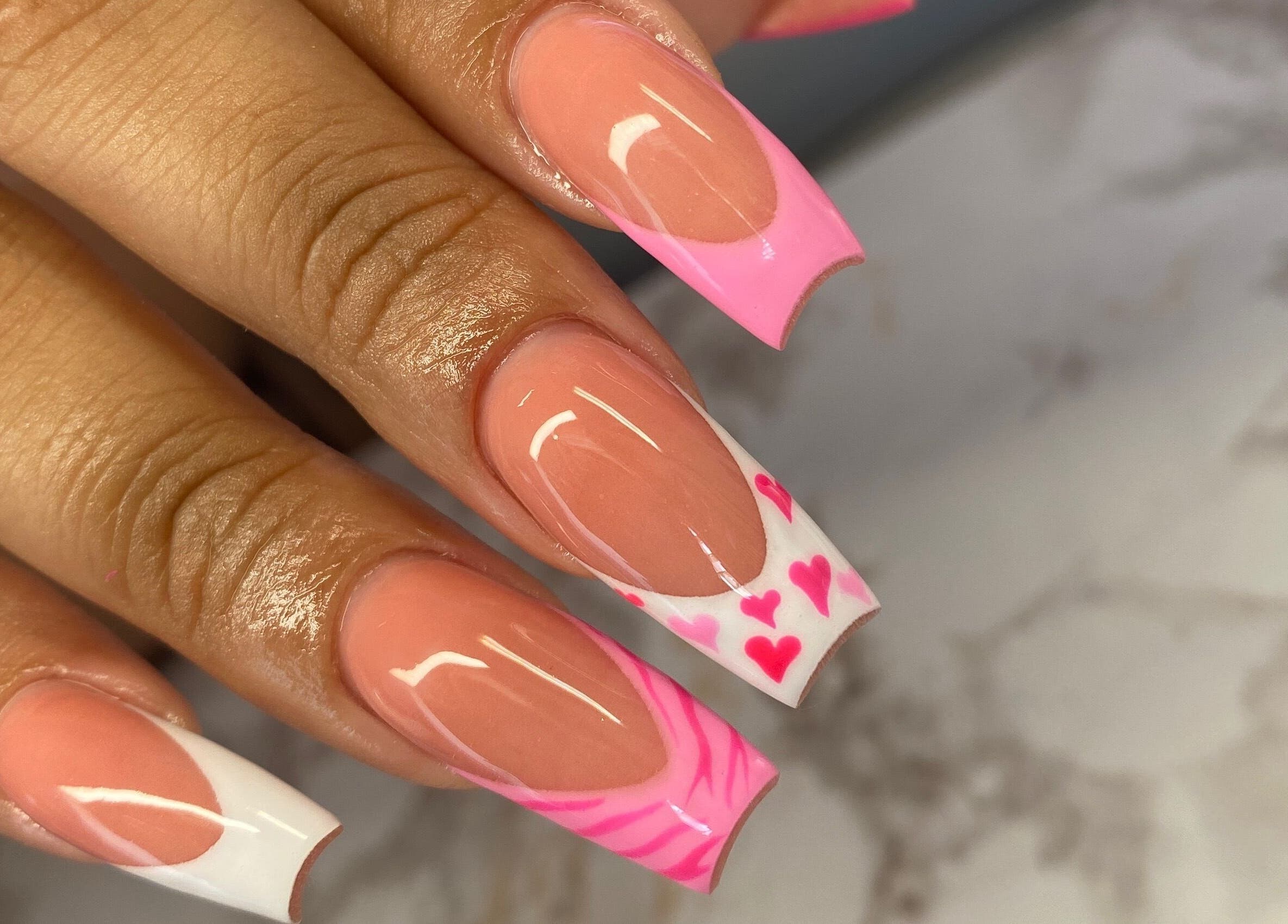 Stylish pink heart nail art at Atinas’ Nail Studio, Oistins, Christ Church, BB. Perfect for a chic look.