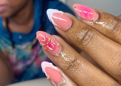 Floral nail art design at Atinas' Nail Studio, Oistins, Christ Church, BB. Vibrant pink and white hues with gold accents.