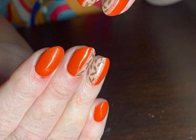 Bright orange nail art at The Nailwork Lounge, Mid Calder, Scotland, GB with intricate accent designs.