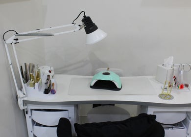 Manicure station at Kals Ladies Salon, Dubai, Dubai, AE, featuring a modern lamp and nail tools.