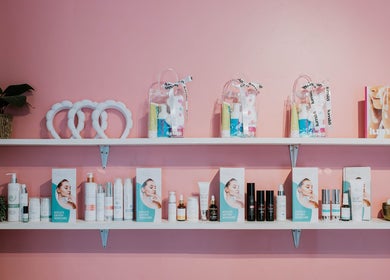Product display at Inge Myburgh Studio, Cape Town, featuring skincare on pink shelves.