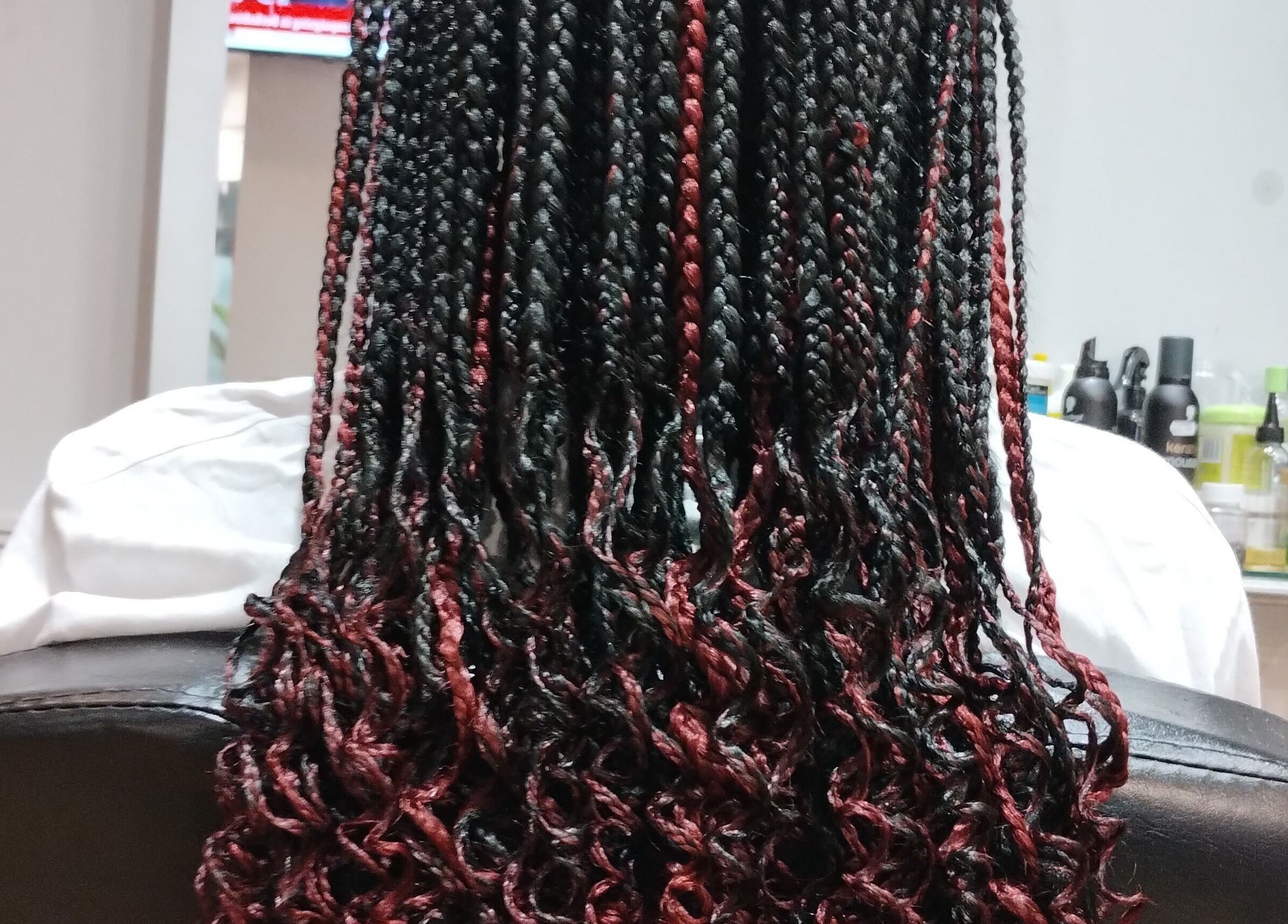 Intricate black and red braids styled at AmiCable Braids, Grantham, England, GB.