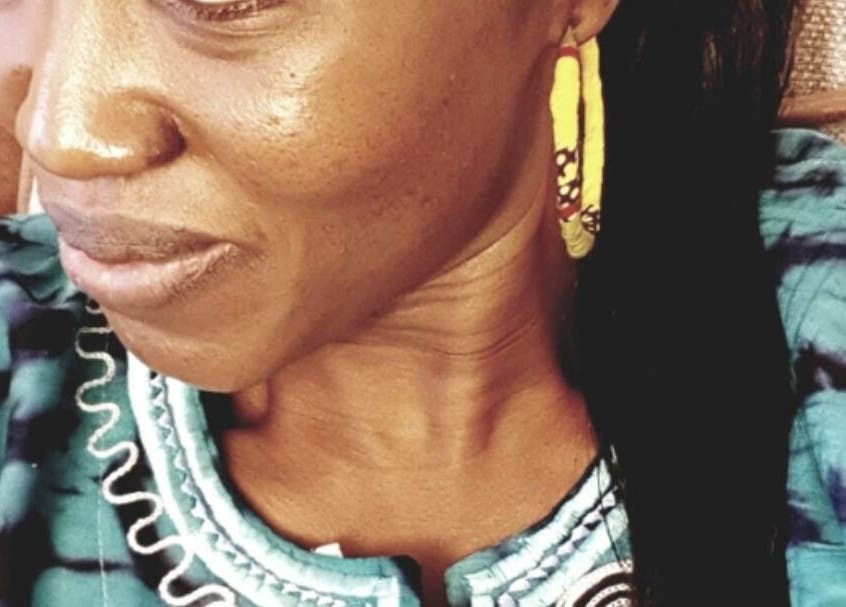 Close-up of a woman with colorful earrings at AmiCable Braids, Grantham, England, GB.
