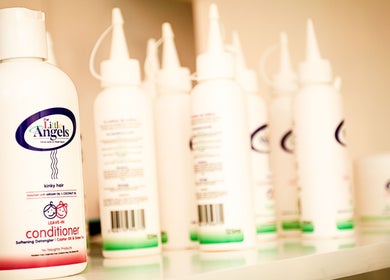 Kurlz & Kutz in Johannesburg, Gauteng, ZA displays a variety of conditioner products on a shelf.