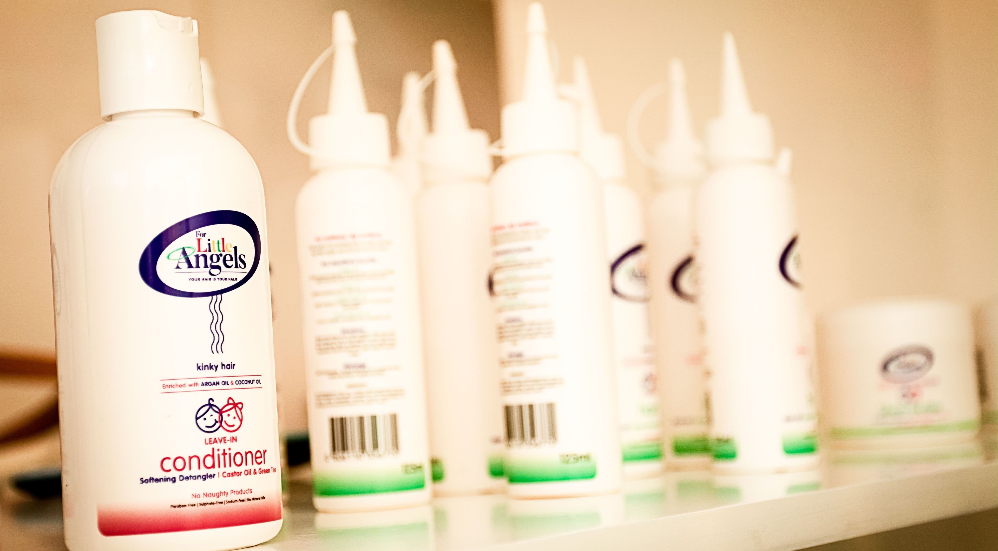 Kurlz & Kutz in Johannesburg, Gauteng, ZA displays a variety of conditioner products on a shelf.