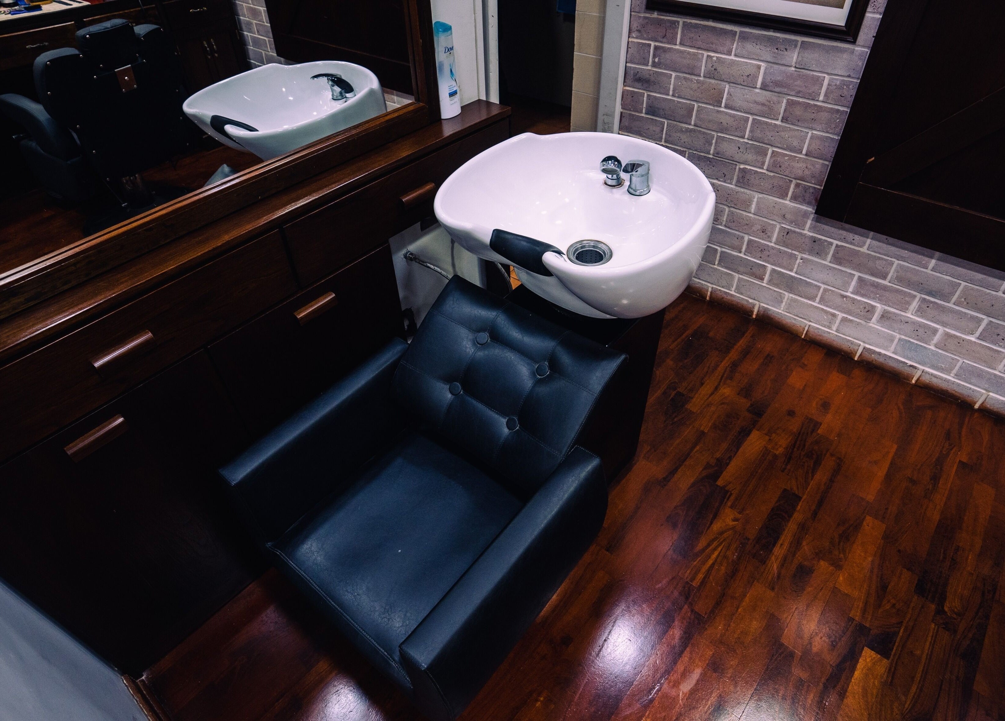 Estación de lavado en Montreal Spa & Barberia, Miraflores, Provincia de Lima, PE, con silla de cuero negro.