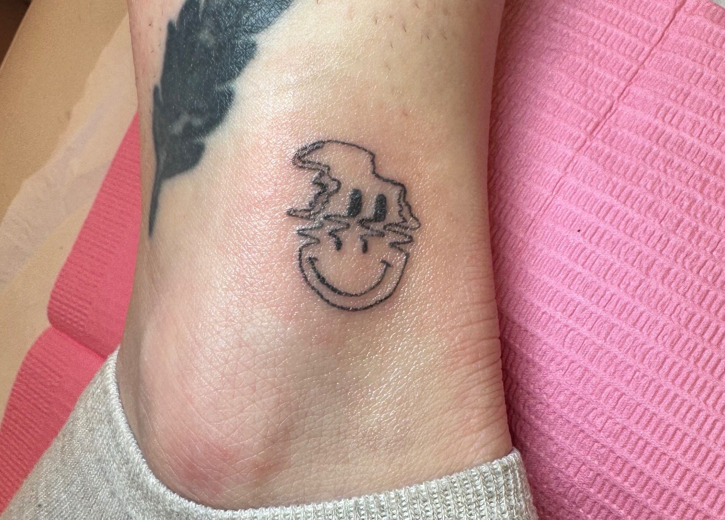 Unique smiley face tattoo offered by Glow Beauty and Aesthetics in Newhall, England, GB.