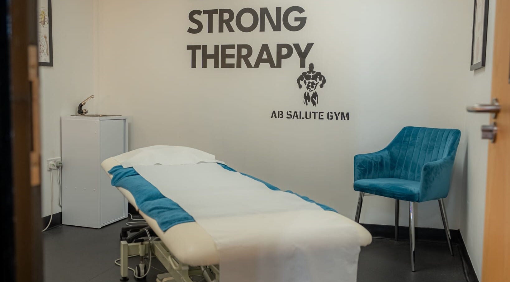 Stay Strong Therapy room in Braintree, England, GB with a treatment table and blue chair.